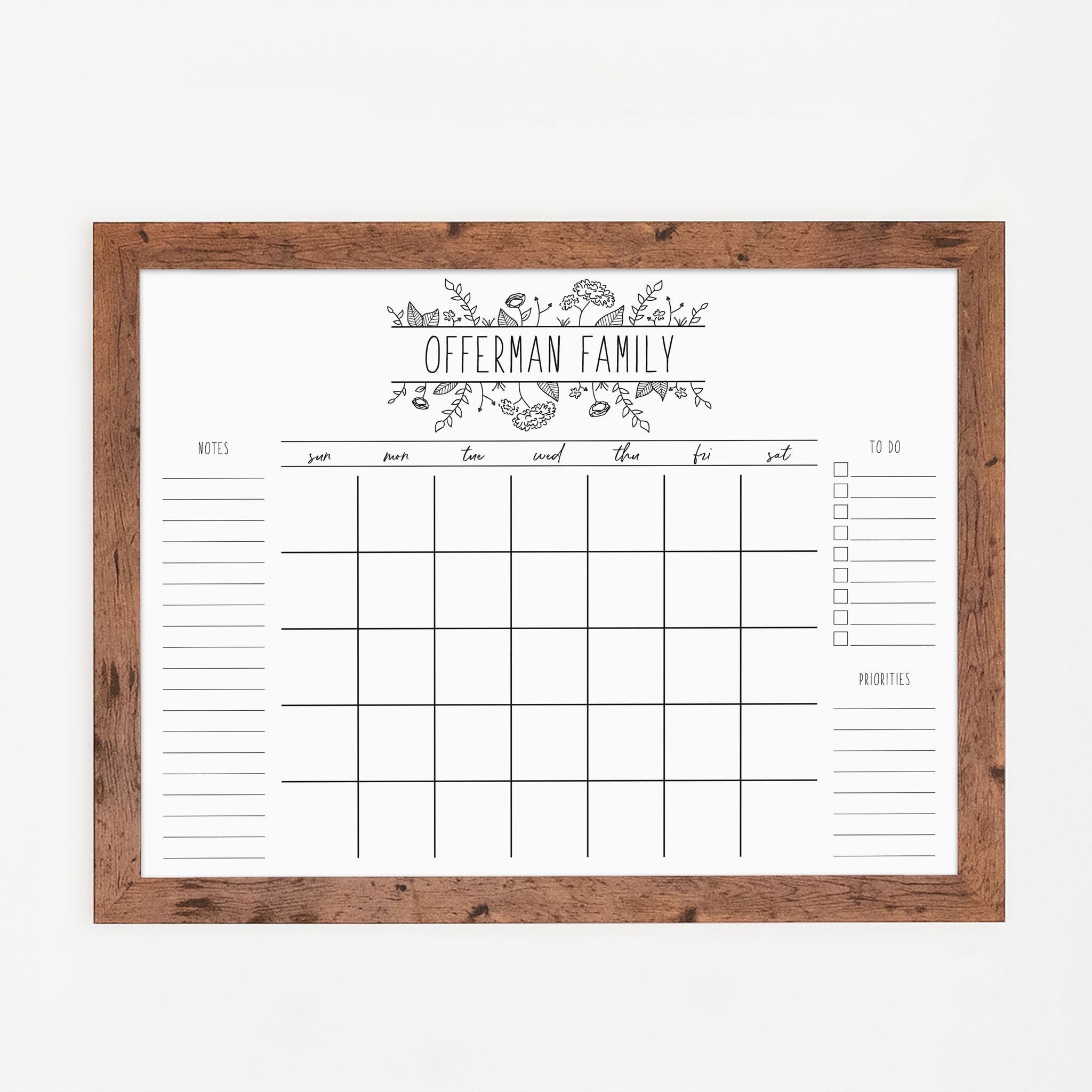 A framed whiteboard monthly calender hanging on the wall