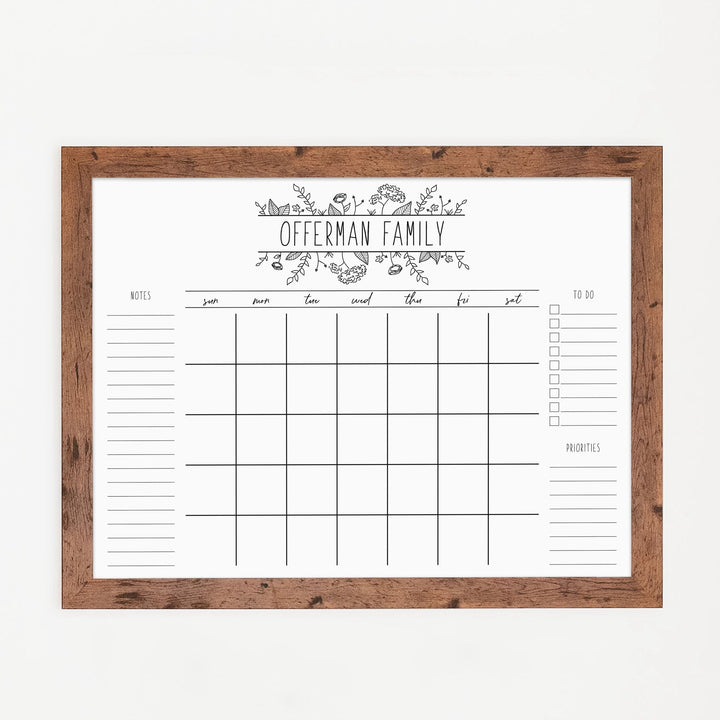 A framed whiteboard monthly calender hanging on the wall