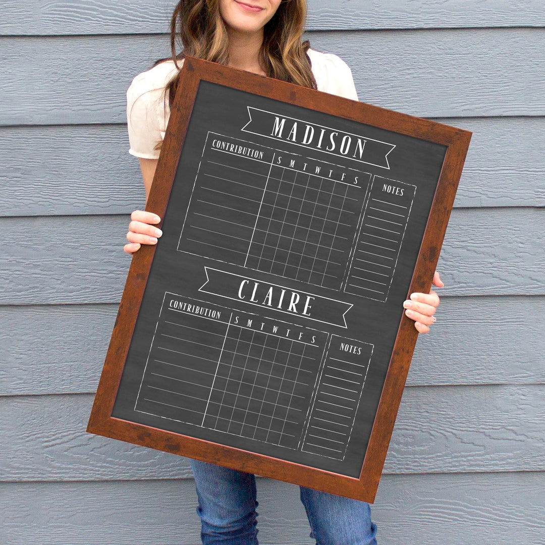 A framed dry-erase chore chart with a chalkboard look hanging on the wall