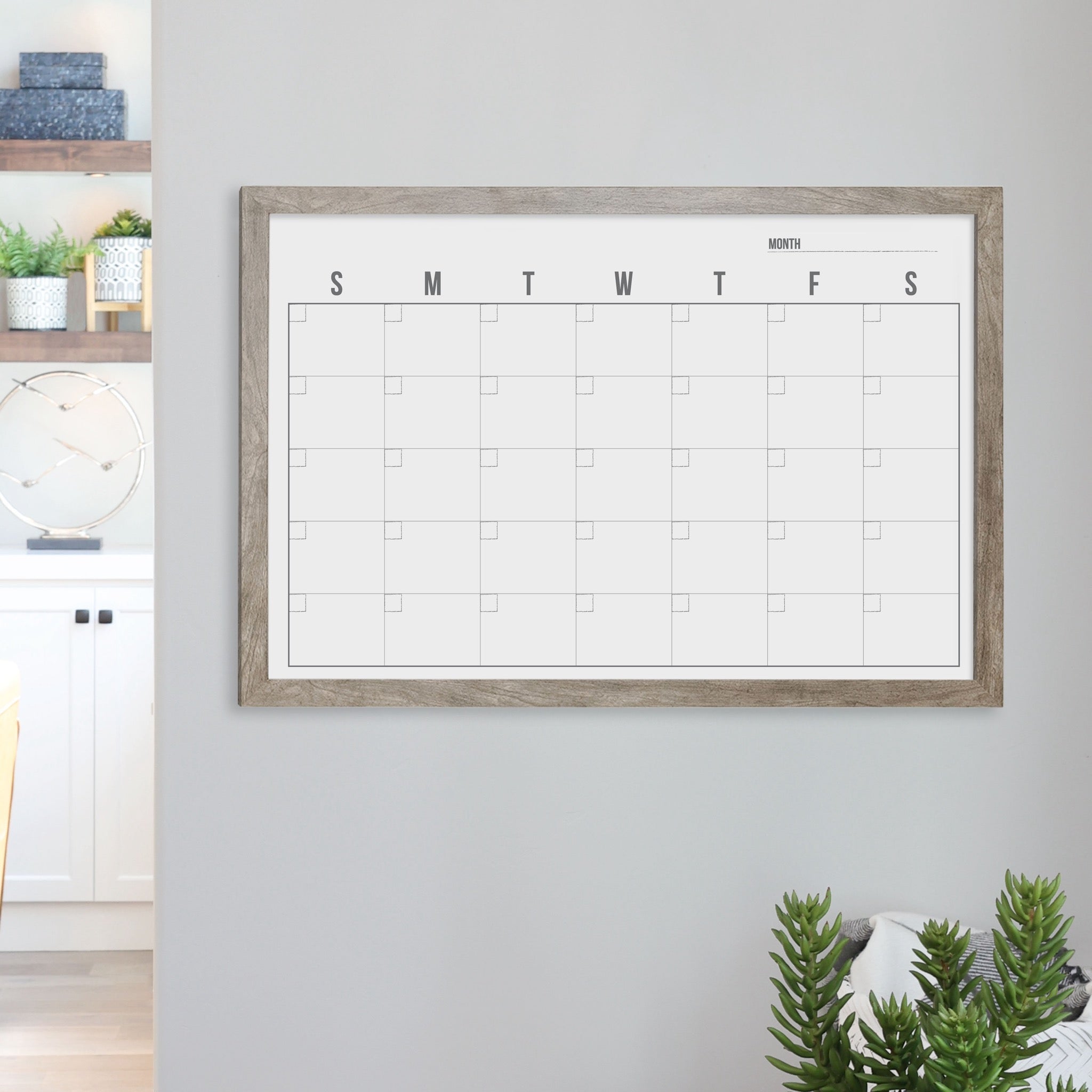 A framed whiteboard monthly calender hanging on the wall