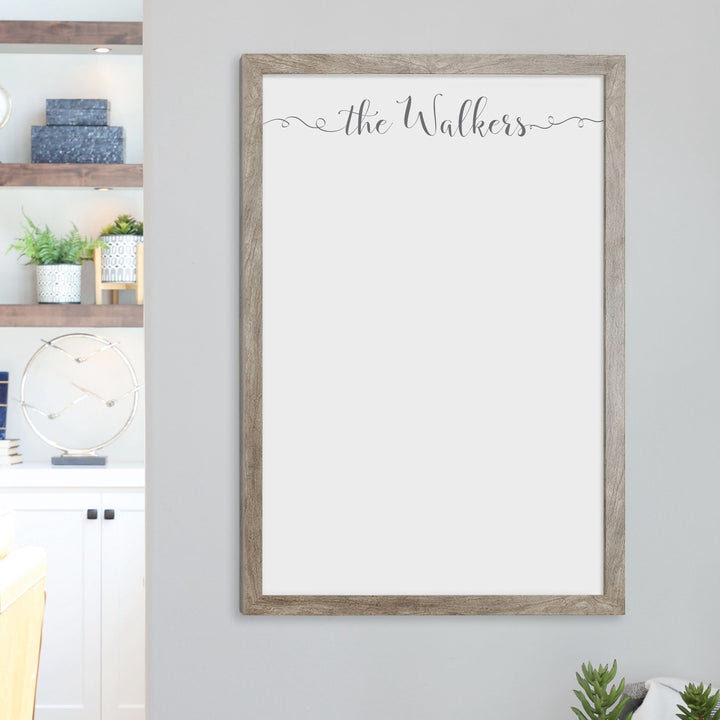 A framed whiteboard calendar with a two month design format hanging on the wall