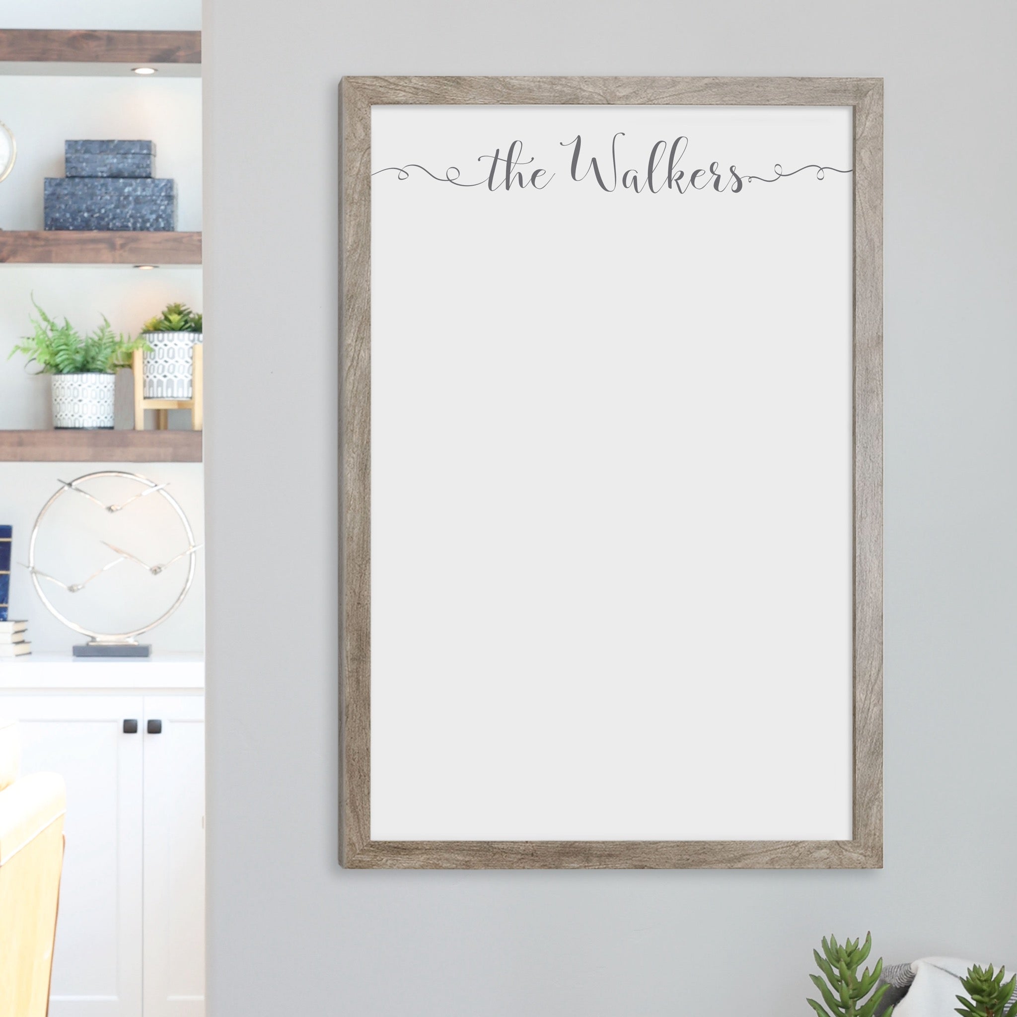 A framed whiteboard calendar with a two month design format hanging on the wall
