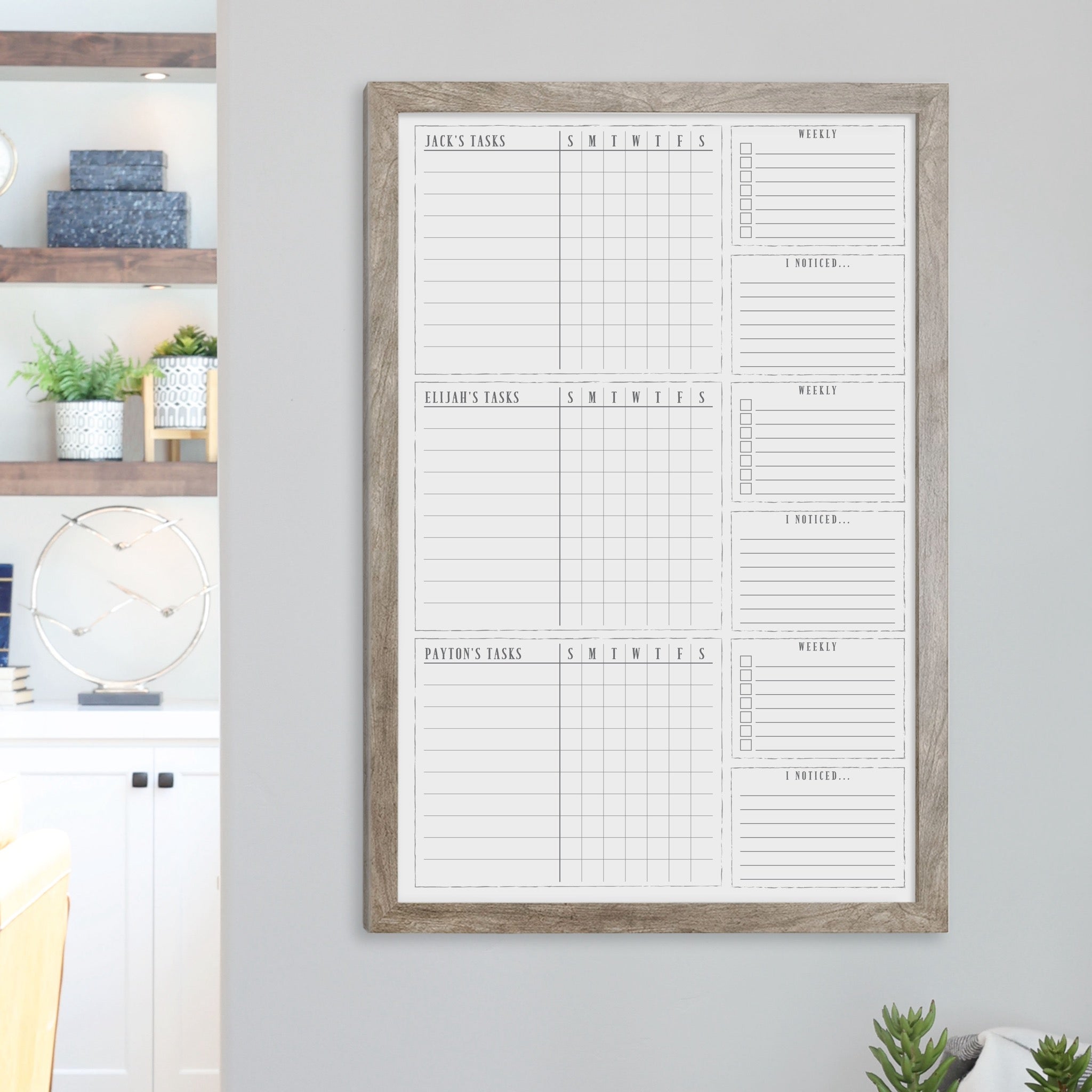 A framed whiteboard chore chart hanging on the wall
