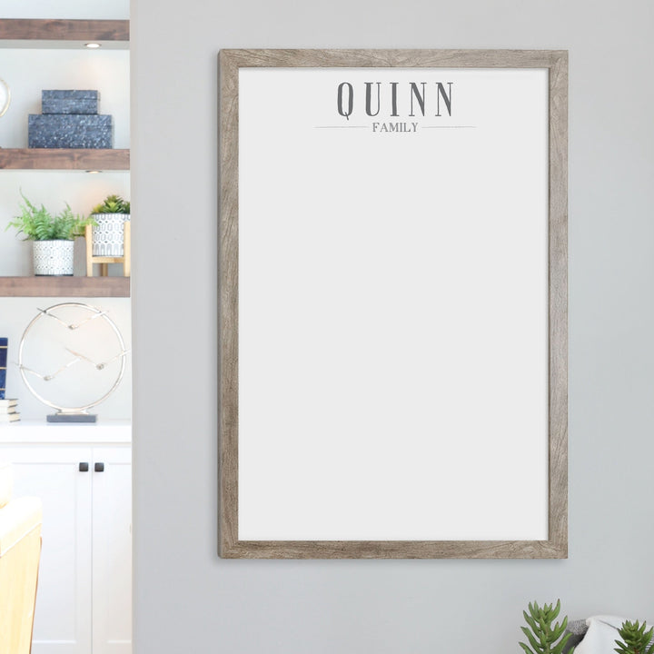 A framed whiteboard calendar with a two month design format hanging on the wall