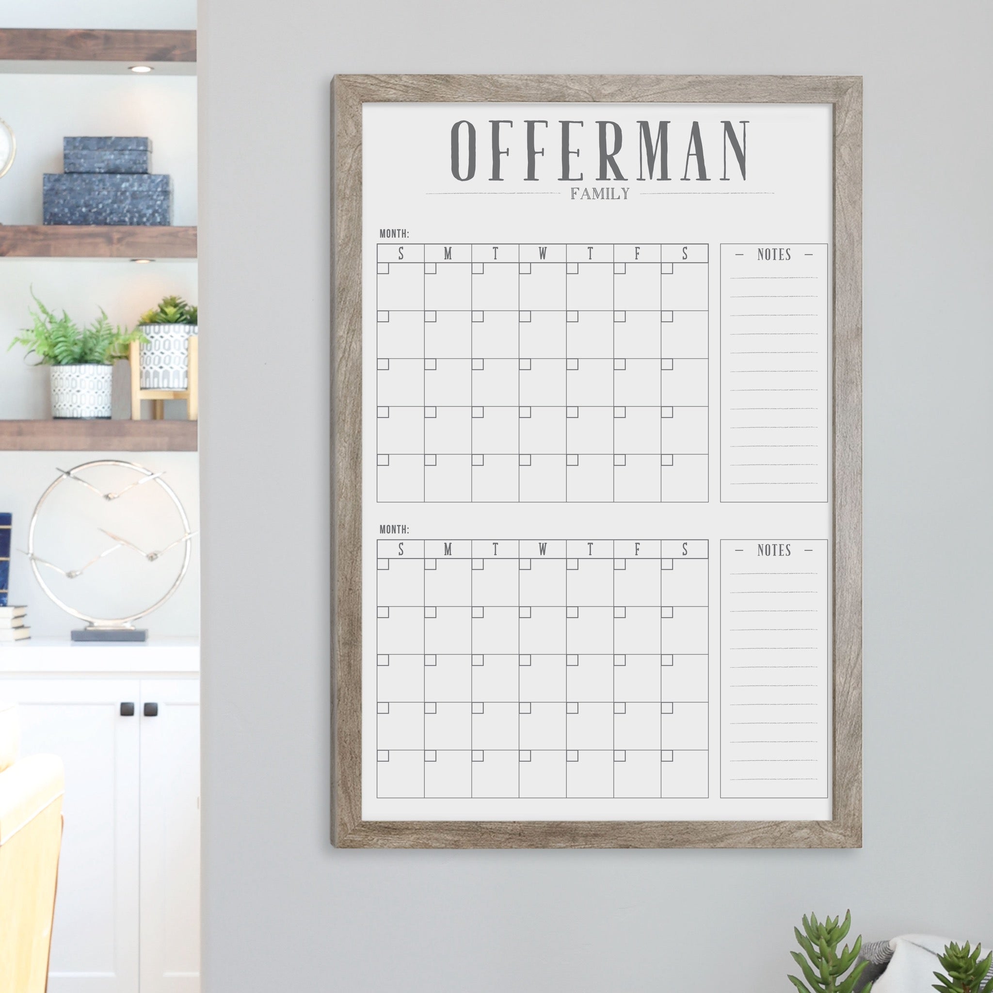 A framed whiteboard calendar with a two month design format hanging on the wall