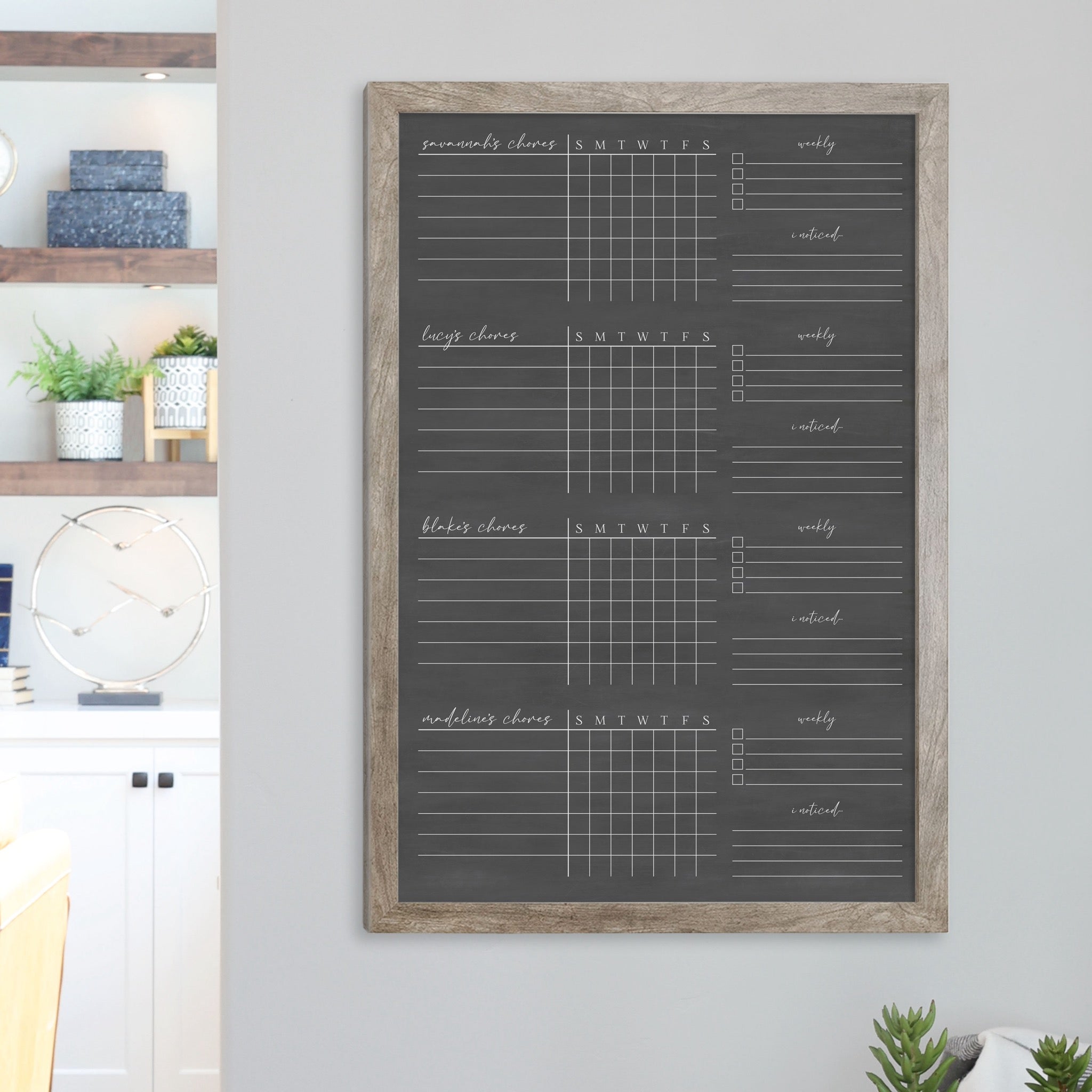 A framed dry-erase chore chart with a chalkboard look hanging on the wall