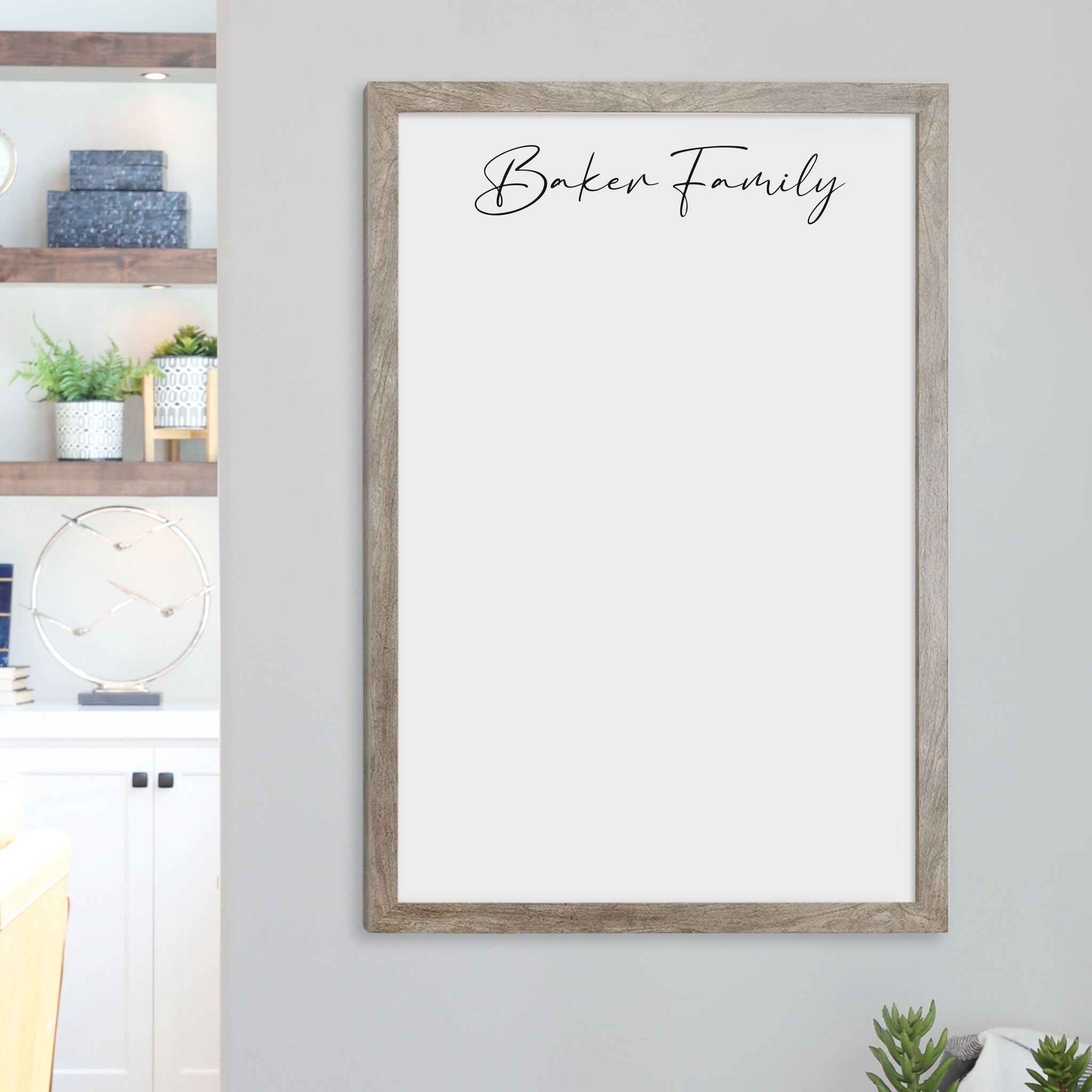 A framed whiteboard calendar with a two month design format hanging on the wall