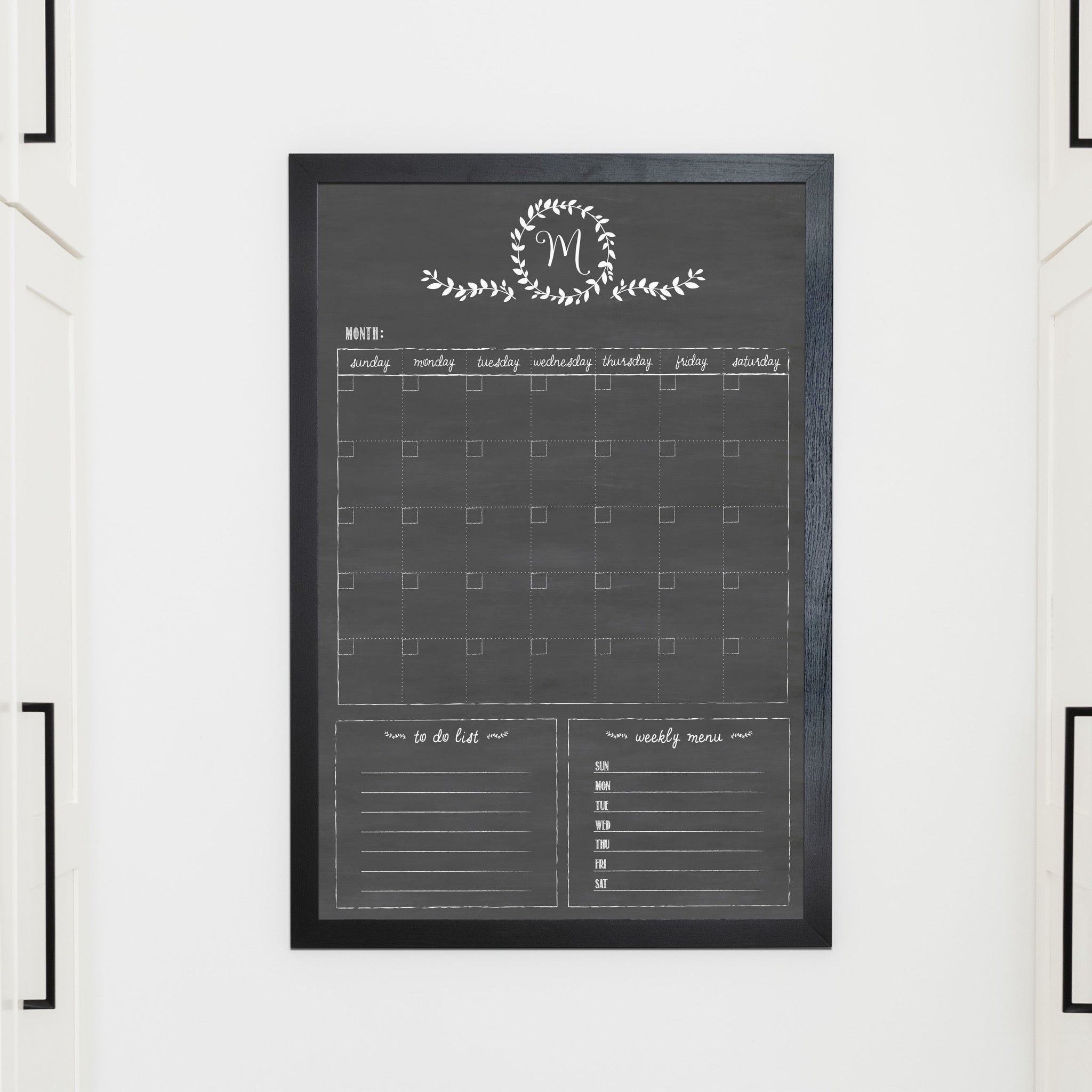 A framed whiteboard monthly calender hanging on the wall