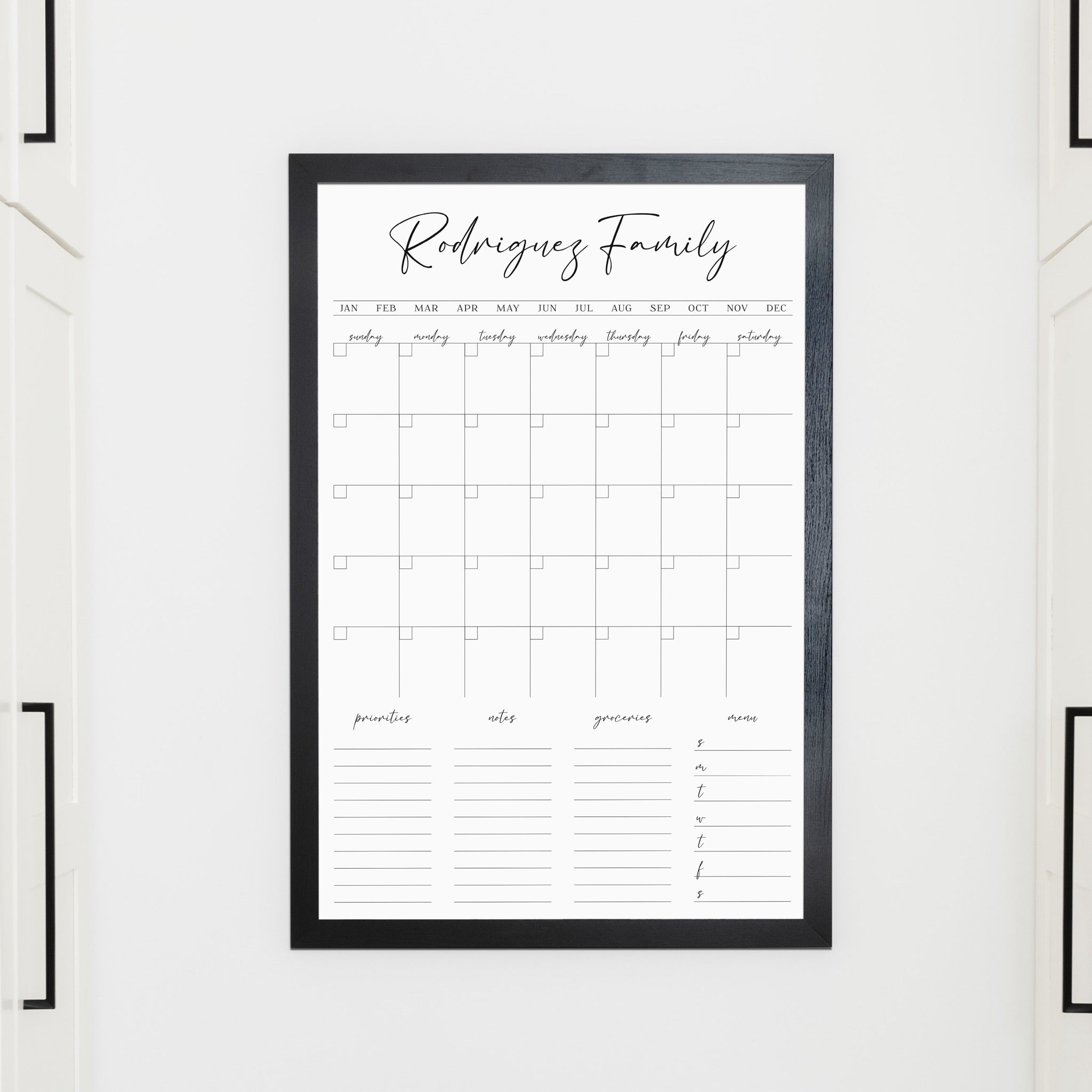 A framed whiteboard family command center hanging on the wall
