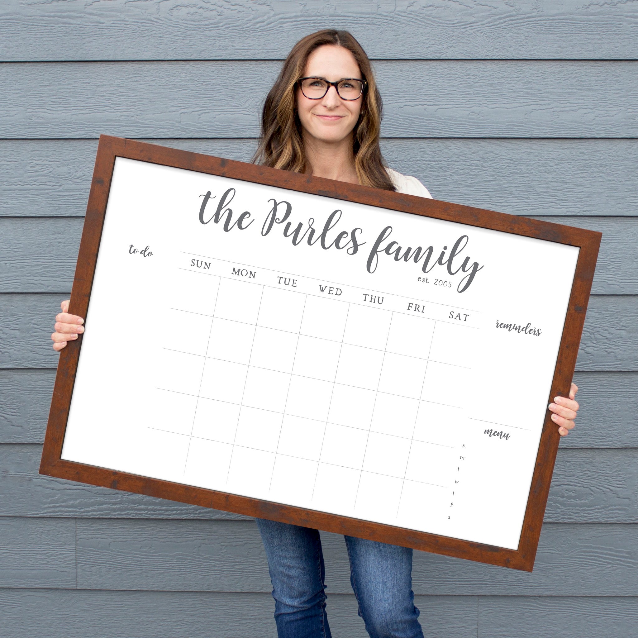 A framed whiteboard monthly calender hanging on the wall