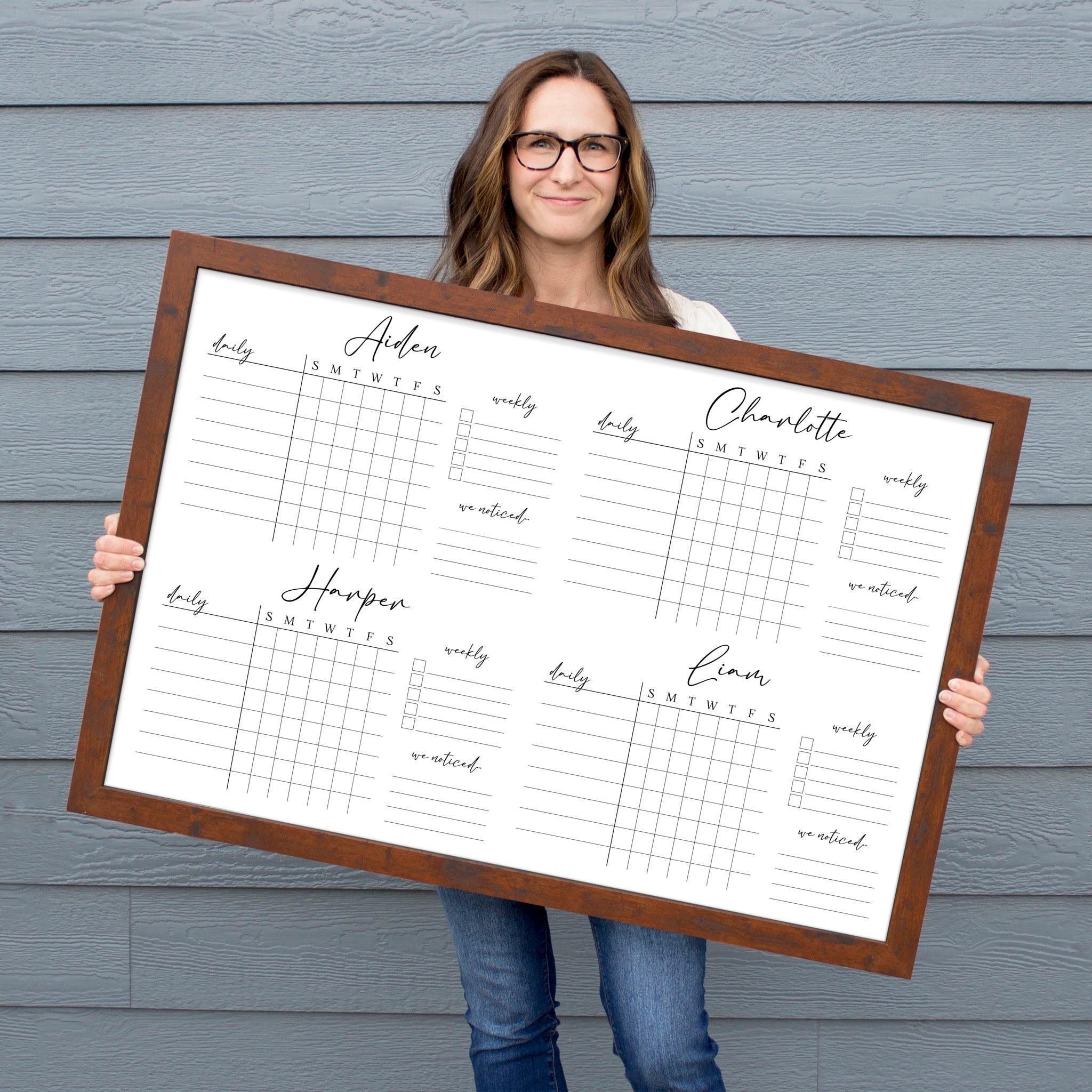 A framed whiteboard chore chart hanging on the wall