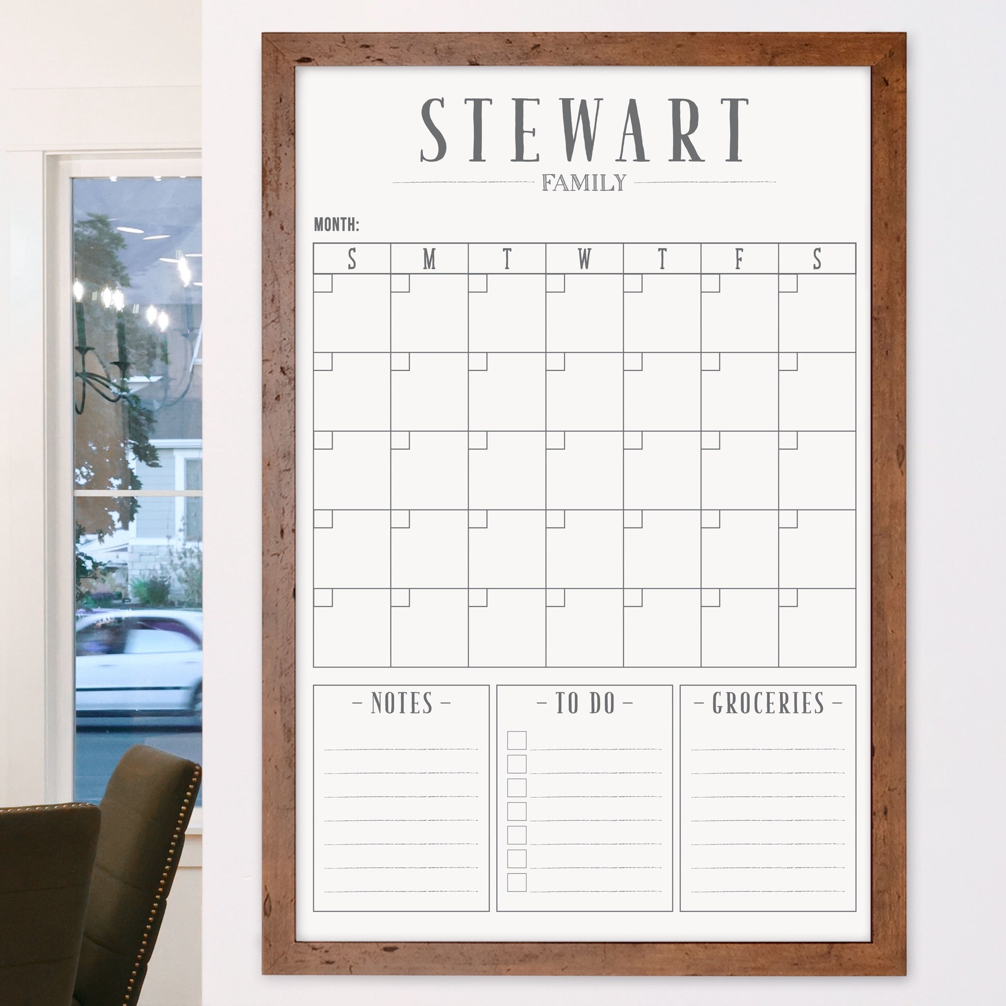 A framed whiteboard monthly calender hanging on the wall