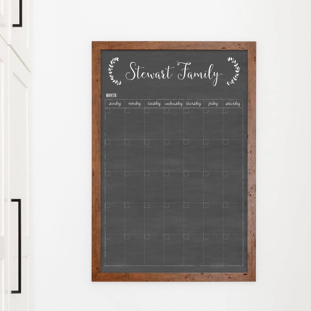 A framed whiteboard monthly calender hanging on the wall