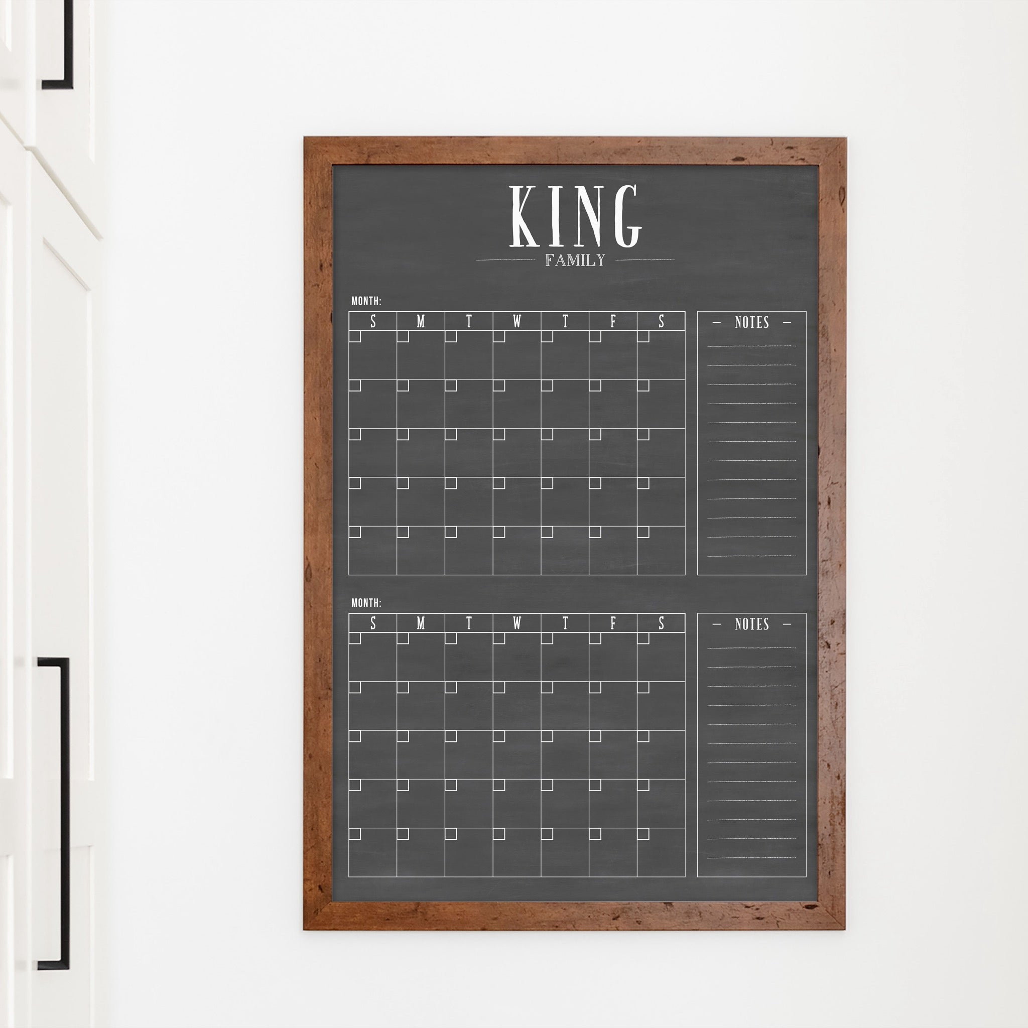 A framed chalkboard dry-erase calendar with a two month design format hanging on the wall