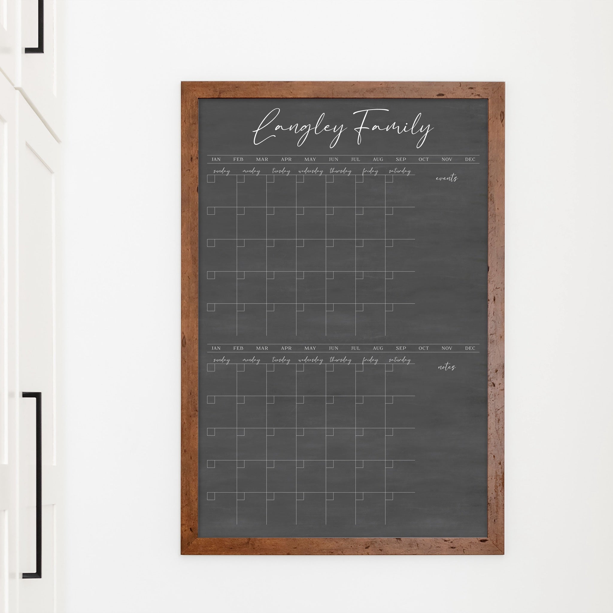 A framed chalkboard dry-erase calendar with a two month design format hanging on the wall