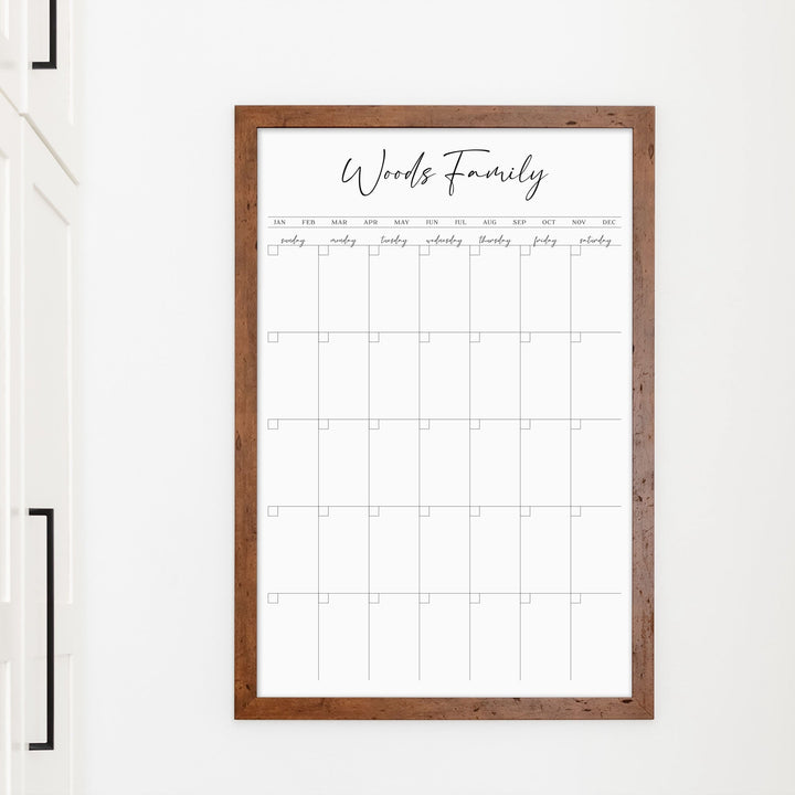 A framed whiteboard monthly calender hanging on the wall