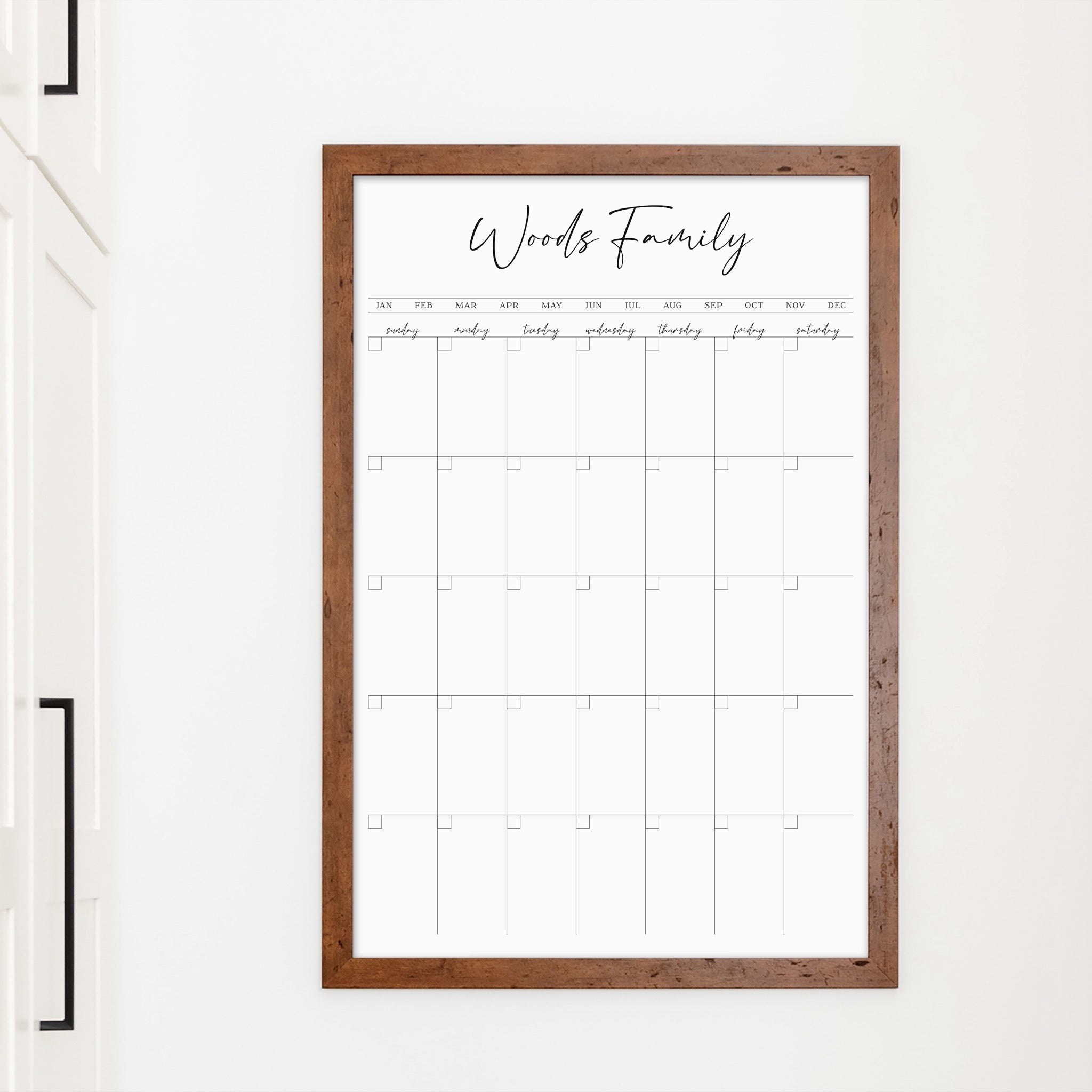 A framed whiteboard monthly calender hanging on the wall