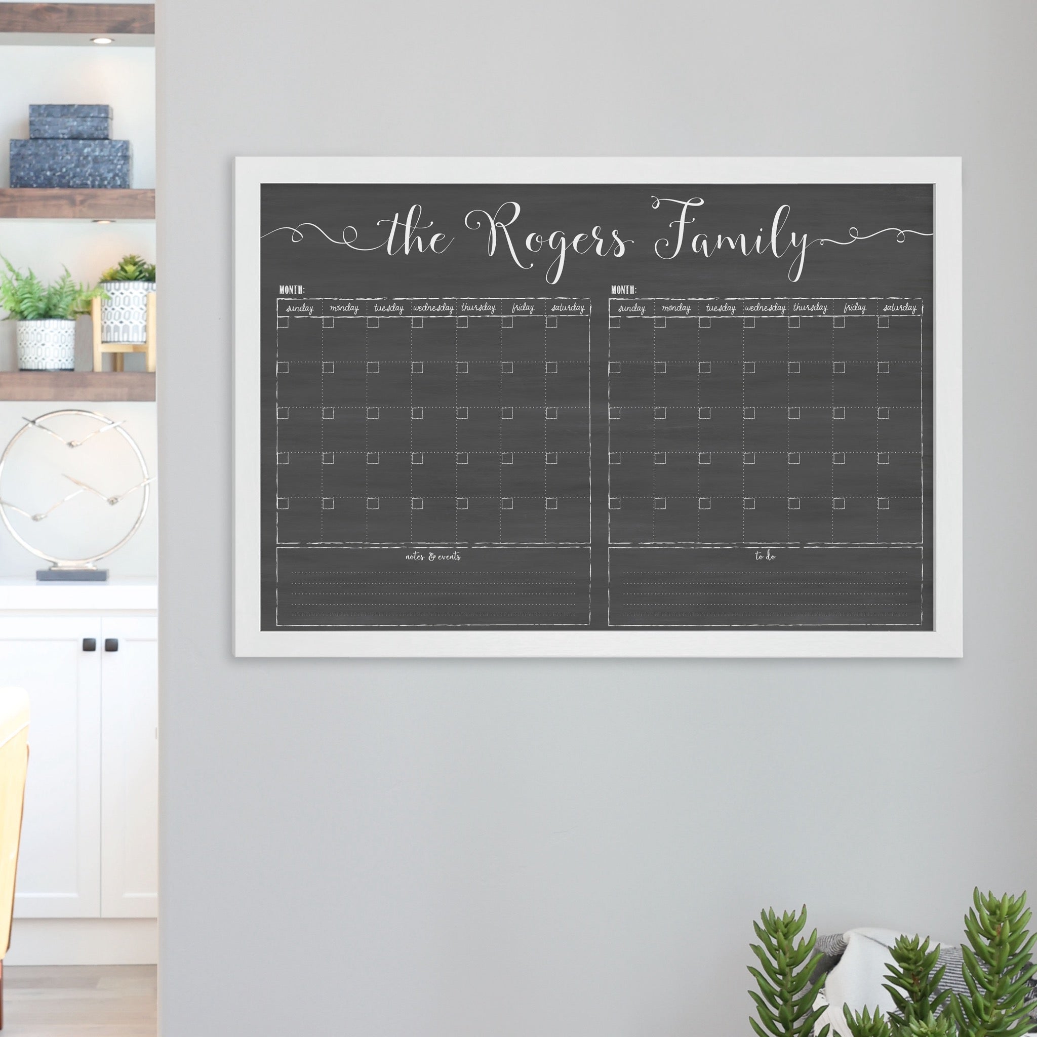 A framed chalkboard dry-erase calendar with a two month design format hanging on the wall