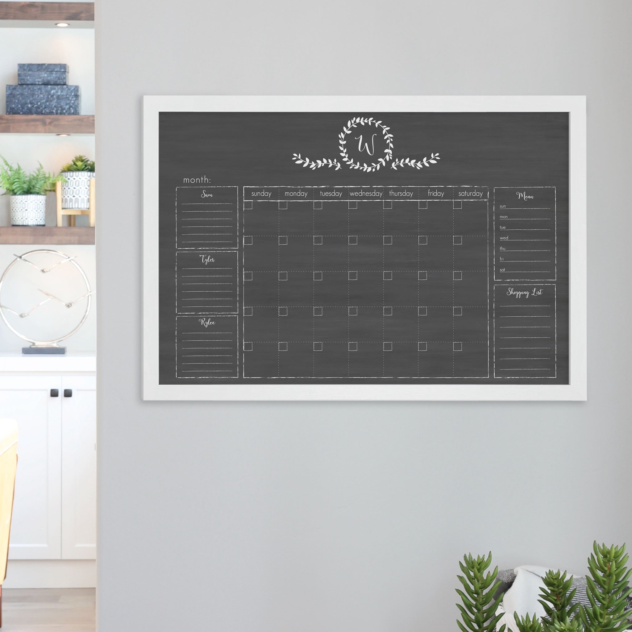 A framed dry-erase family command center with a faux chalkboard look hanging on the wall