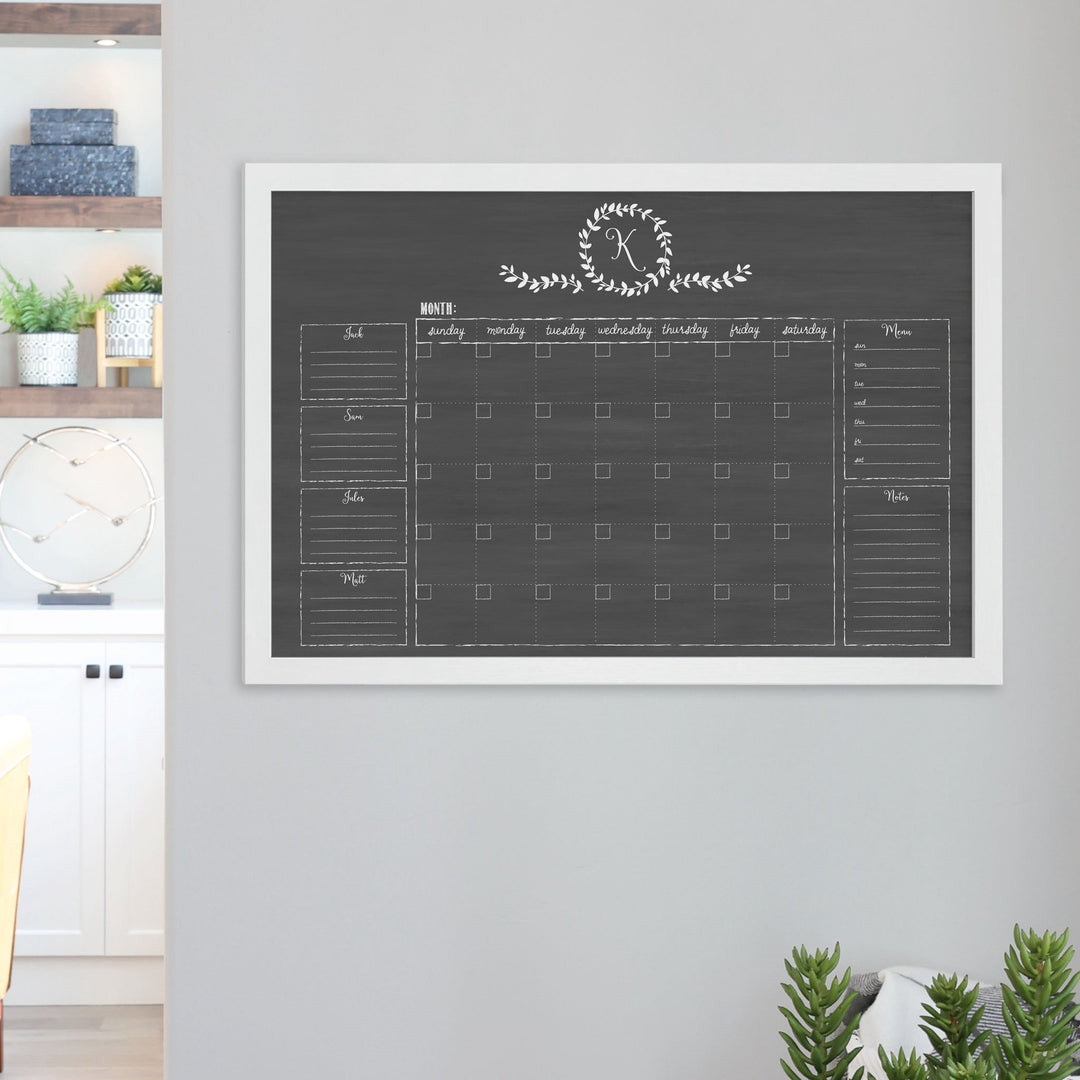 A framed dry-erase family command center with a faux chalkboard look hanging on the wall
