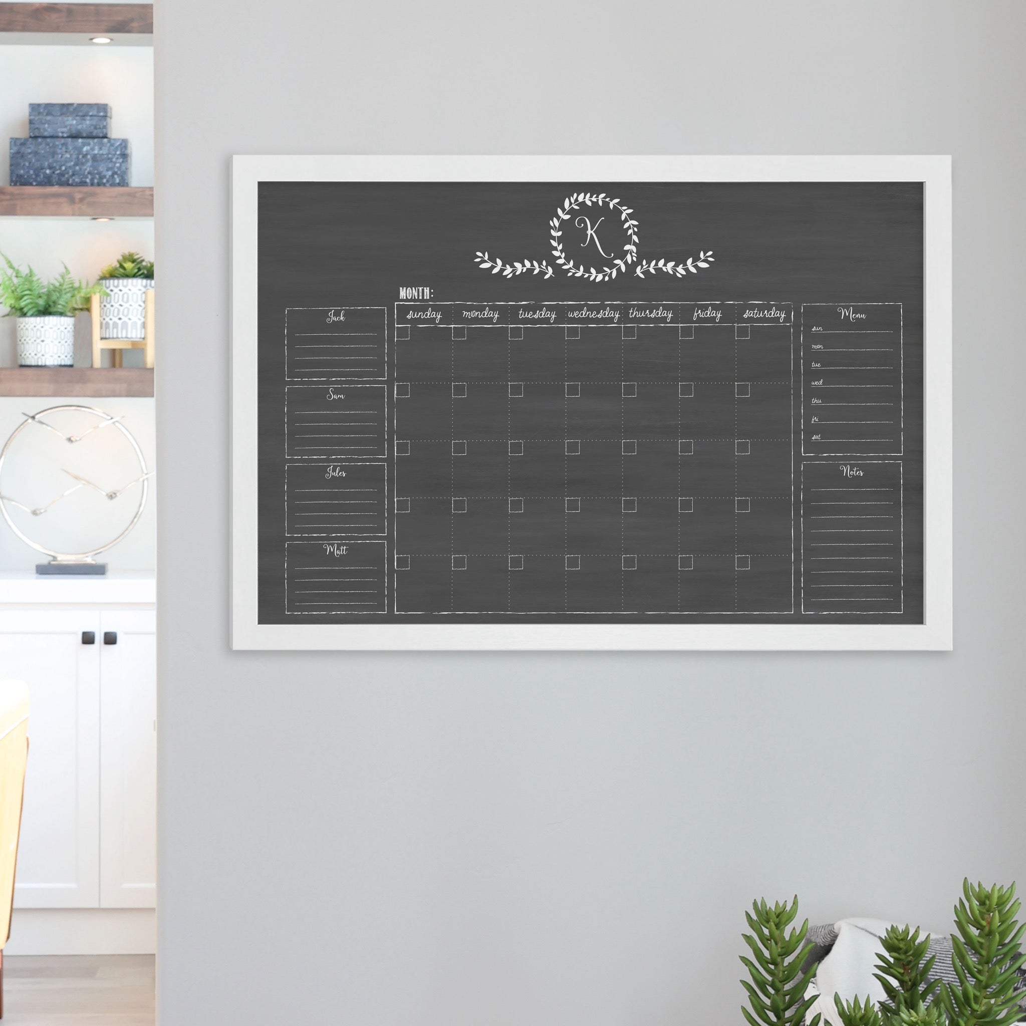 A framed dry-erase family command center with a faux chalkboard look hanging on the wall
