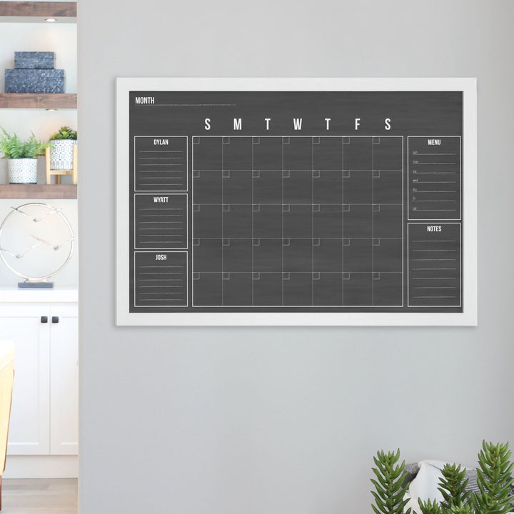 A framed dry-erase family command center with a faux chalkboard look hanging on the wall