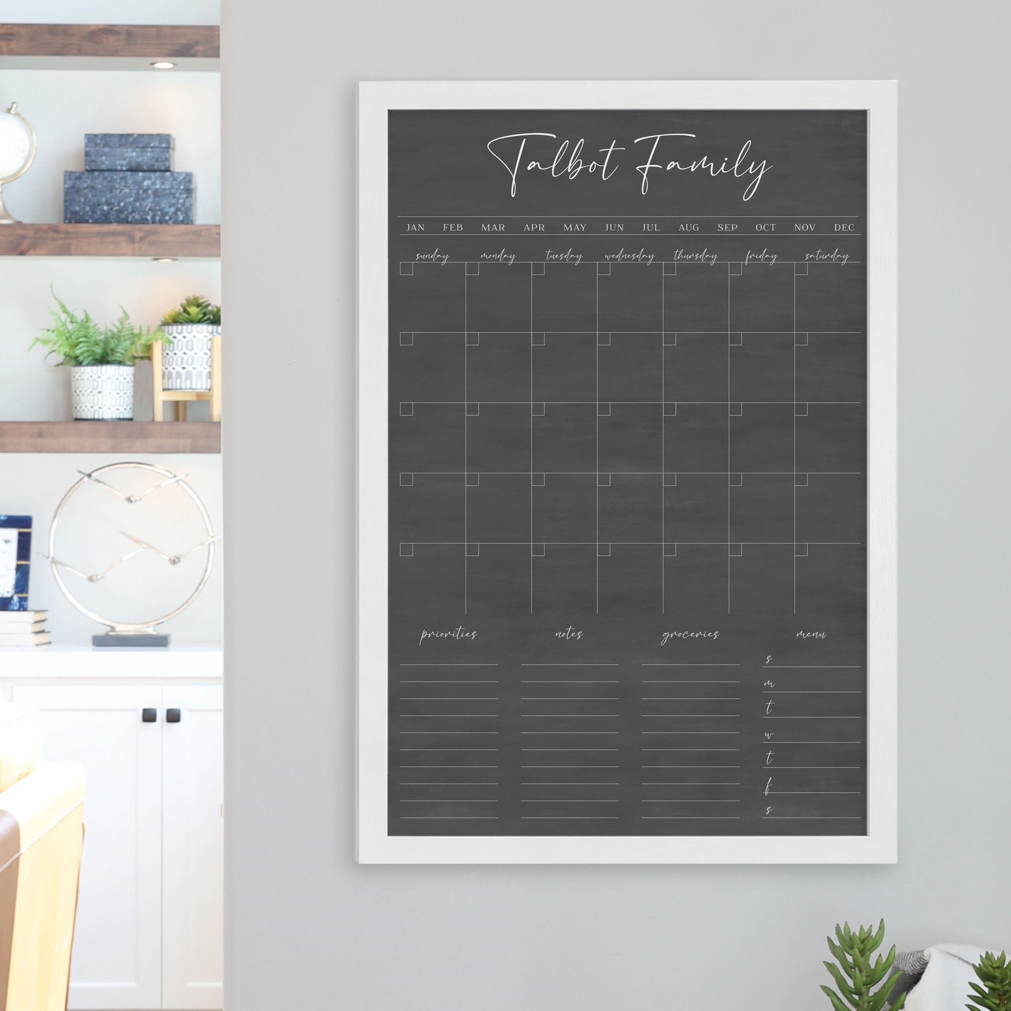 A framed dry-erase family command center with a faux chalkboard look hanging on the wall