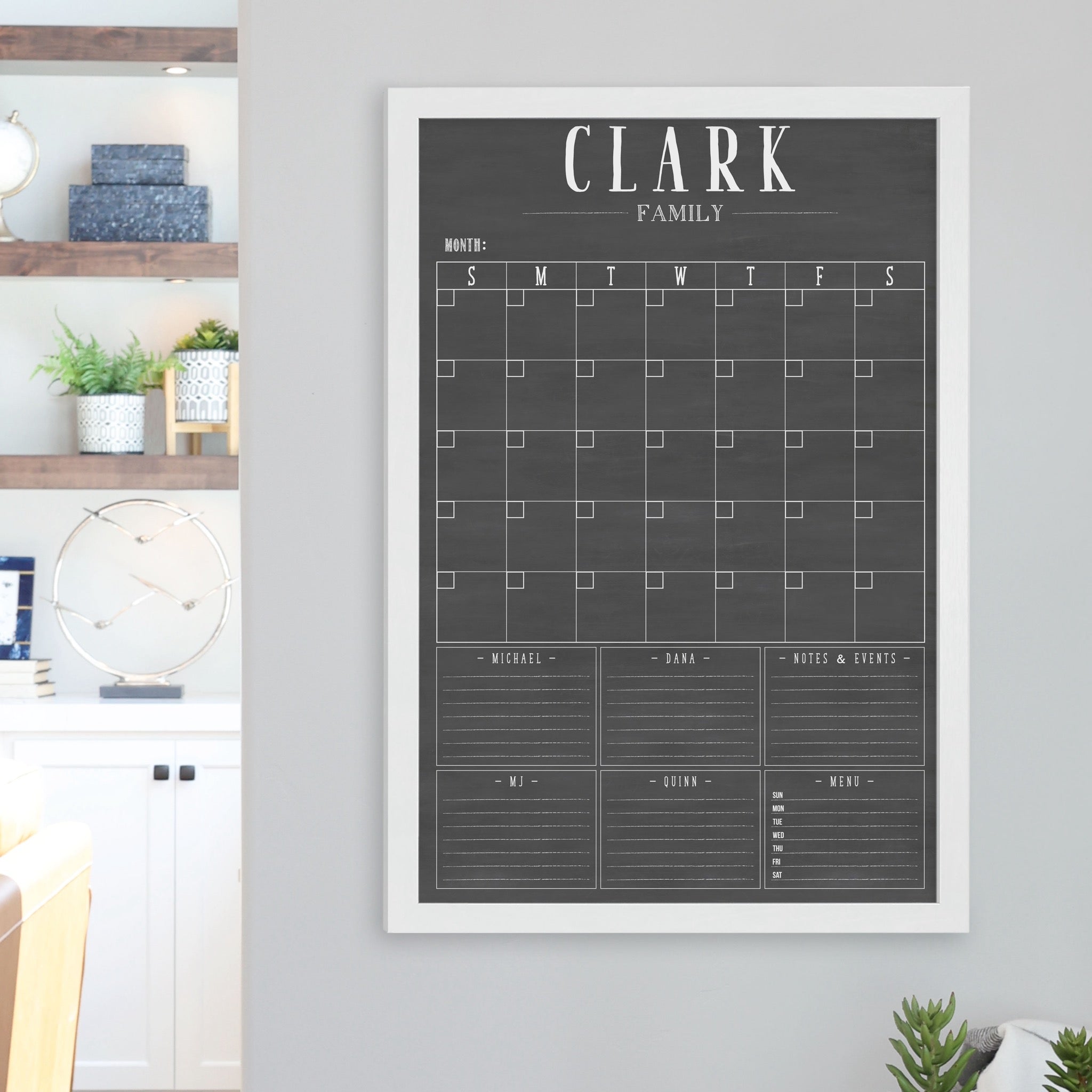 A framed dry-erase family command center with a faux chalkboard look hanging on the wall