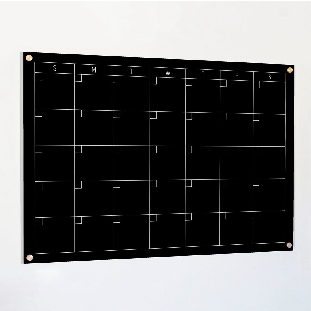 A Dry-erase monthly calender made of acrylic hanging on the wall