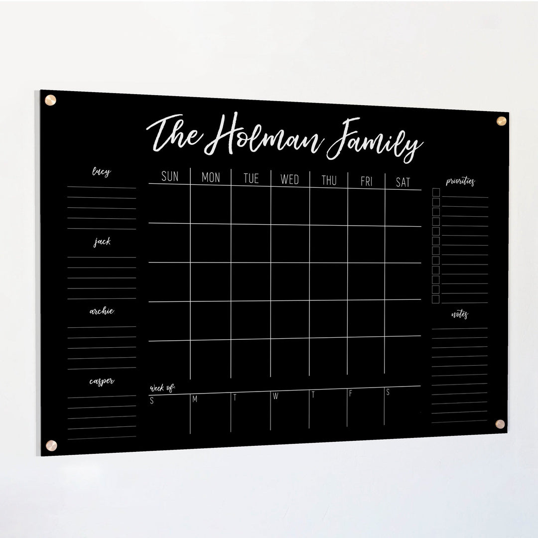 A Dry-erase calendar with a monthly and weekly format made of acrylic hanging on the wall