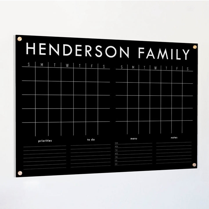 A Dry-erase acrylic calendar with a two month design format hanging on the wall