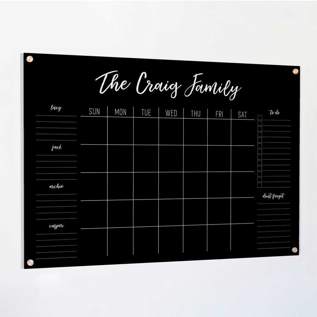 A Dry-erase family command center made of acrylic hanging on the wall