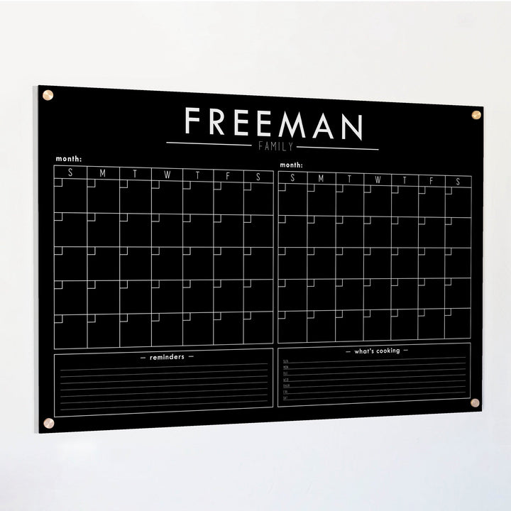A Dry-erase acrylic calendar with a two month design format hanging on the wall