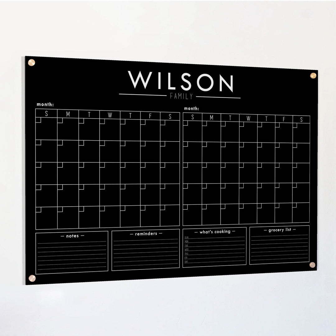 A Dry-erase acrylic calendar with a two month design format hanging on the wall