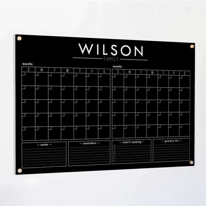 A Dry-erase acrylic calendar with a two month design format hanging on the wall