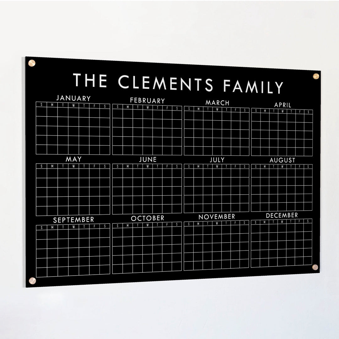 A dry-erase yearly calendar made of acrylic hanging up on the wall