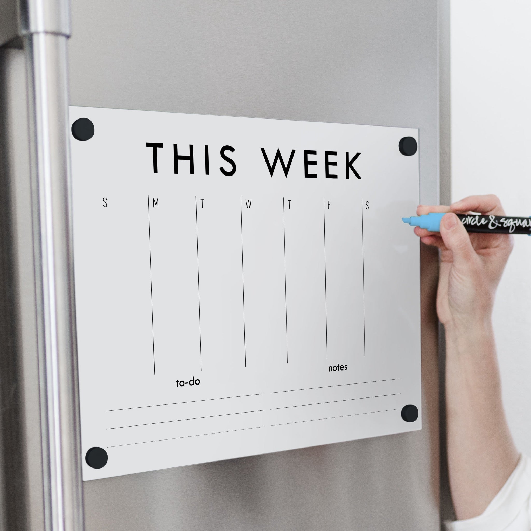 A Dry-erase weekly calender made of magnetic acrylic hanging on the fridge