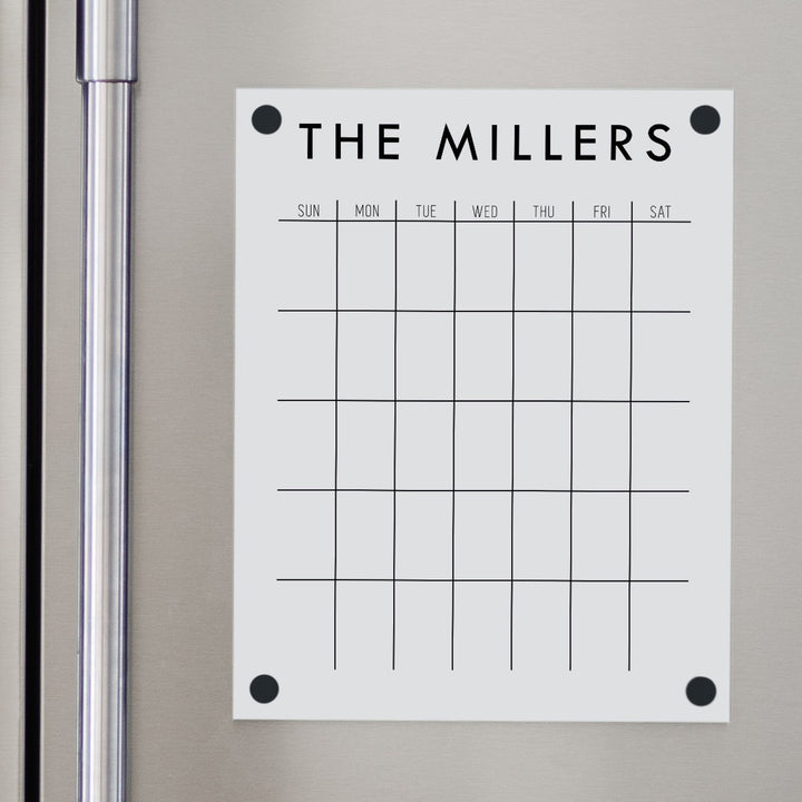 A Dry-erase monthly calender made of magnetic acrylic hanging on the fridge