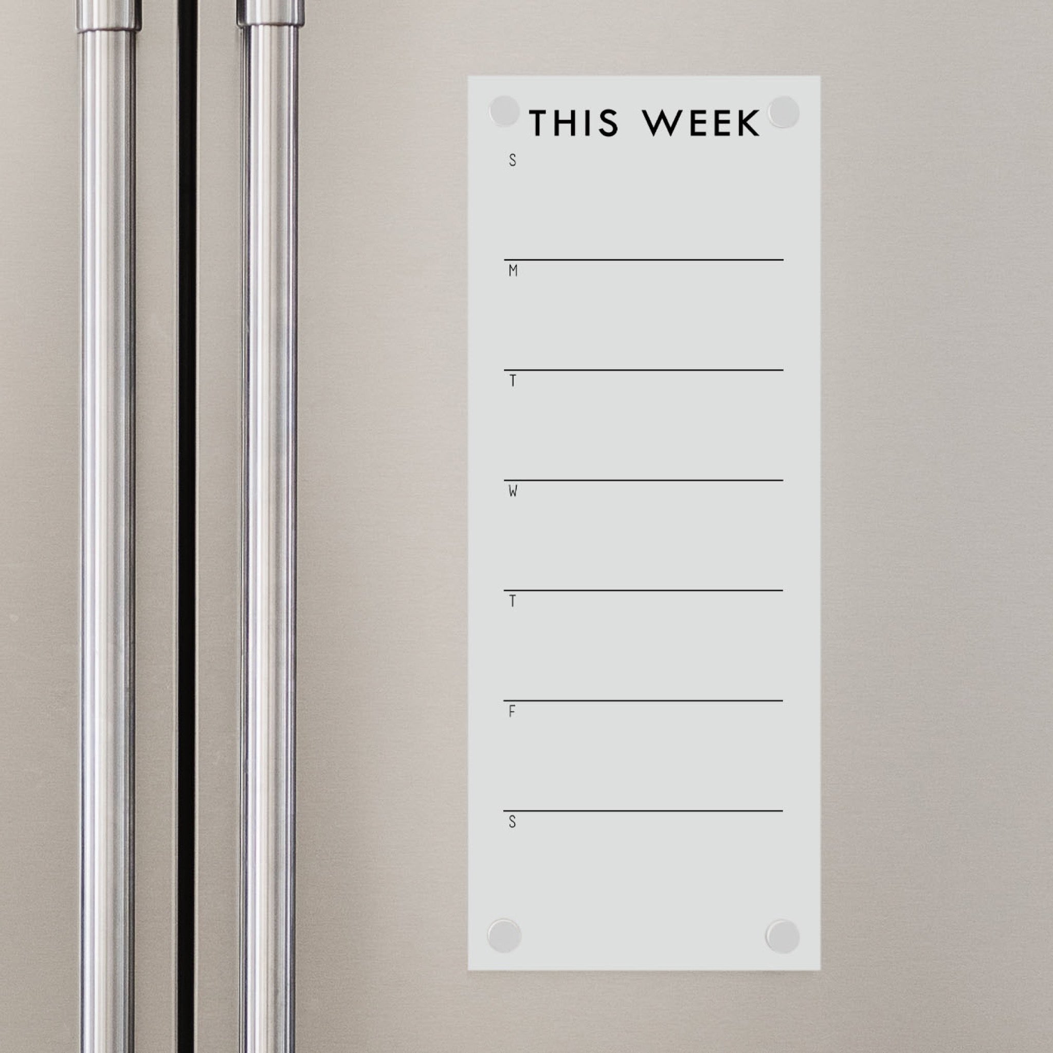 A skinny dry-erase weekly calender made of magnetic acrylic hanging on the fridge