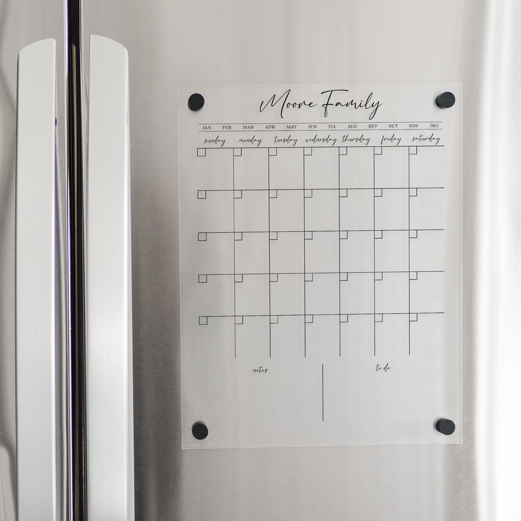 A Dry-erase monthly calender made of magnetic acrylic hanging on the fridge