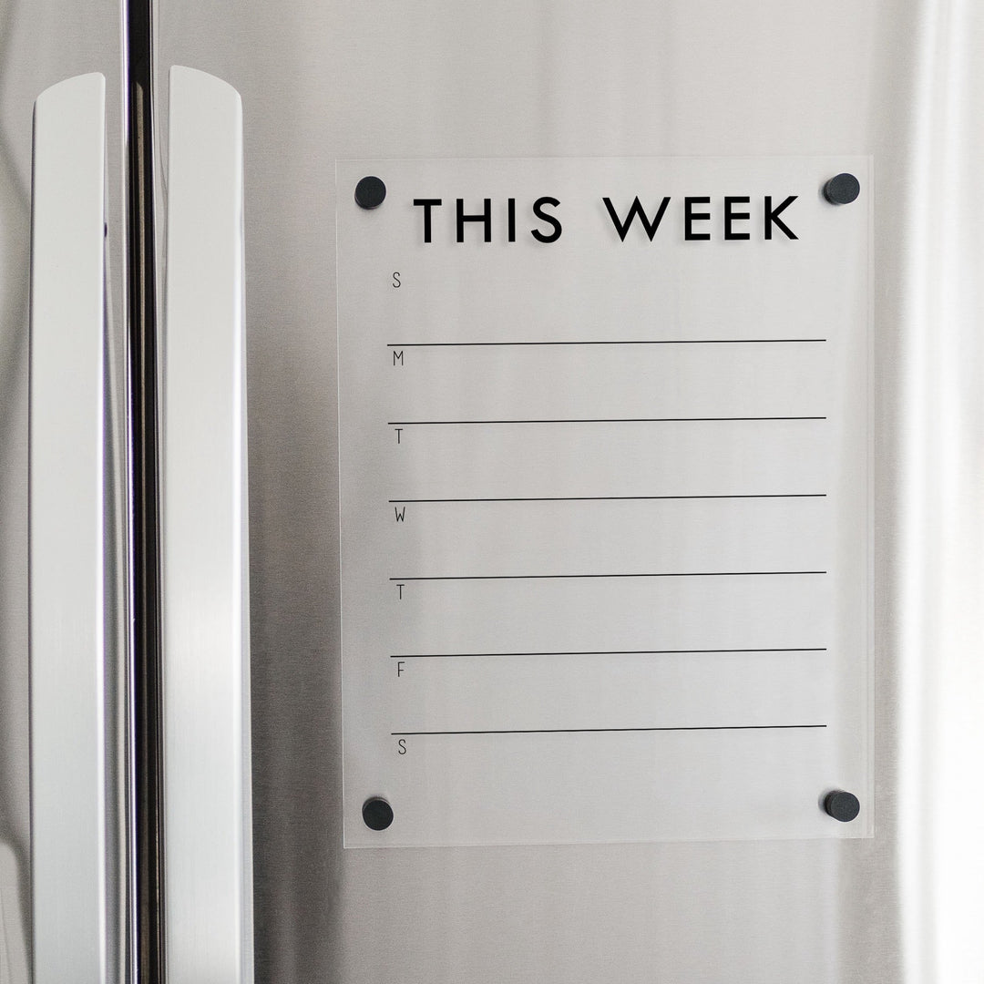 A Dry-erase weekly calender made of magnetic acrylic hanging on the fridge