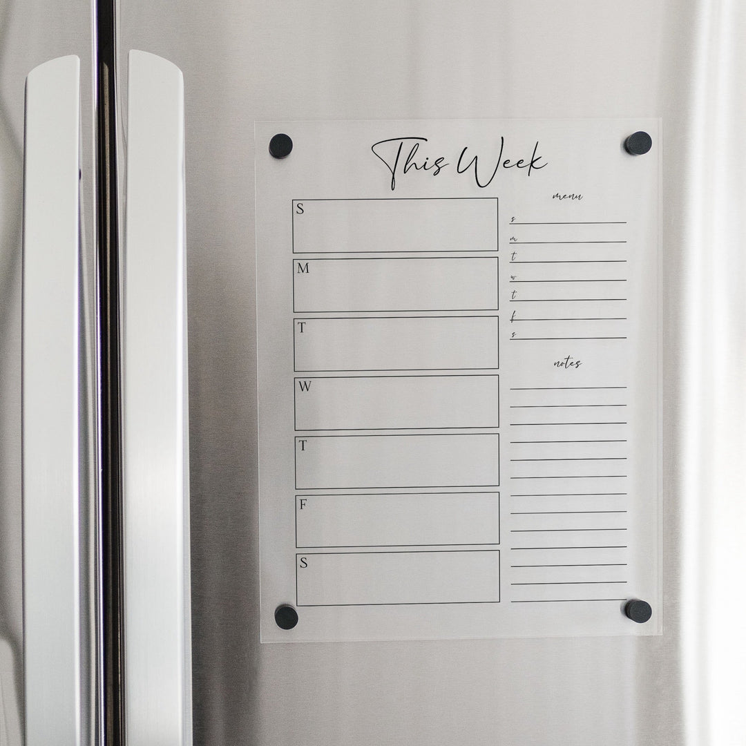 A Dry-erase weekly calender made of magnetic acrylic hanging on the fridge