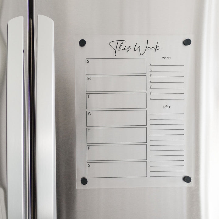 A Dry-erase weekly calender made of magnetic acrylic hanging on the fridge