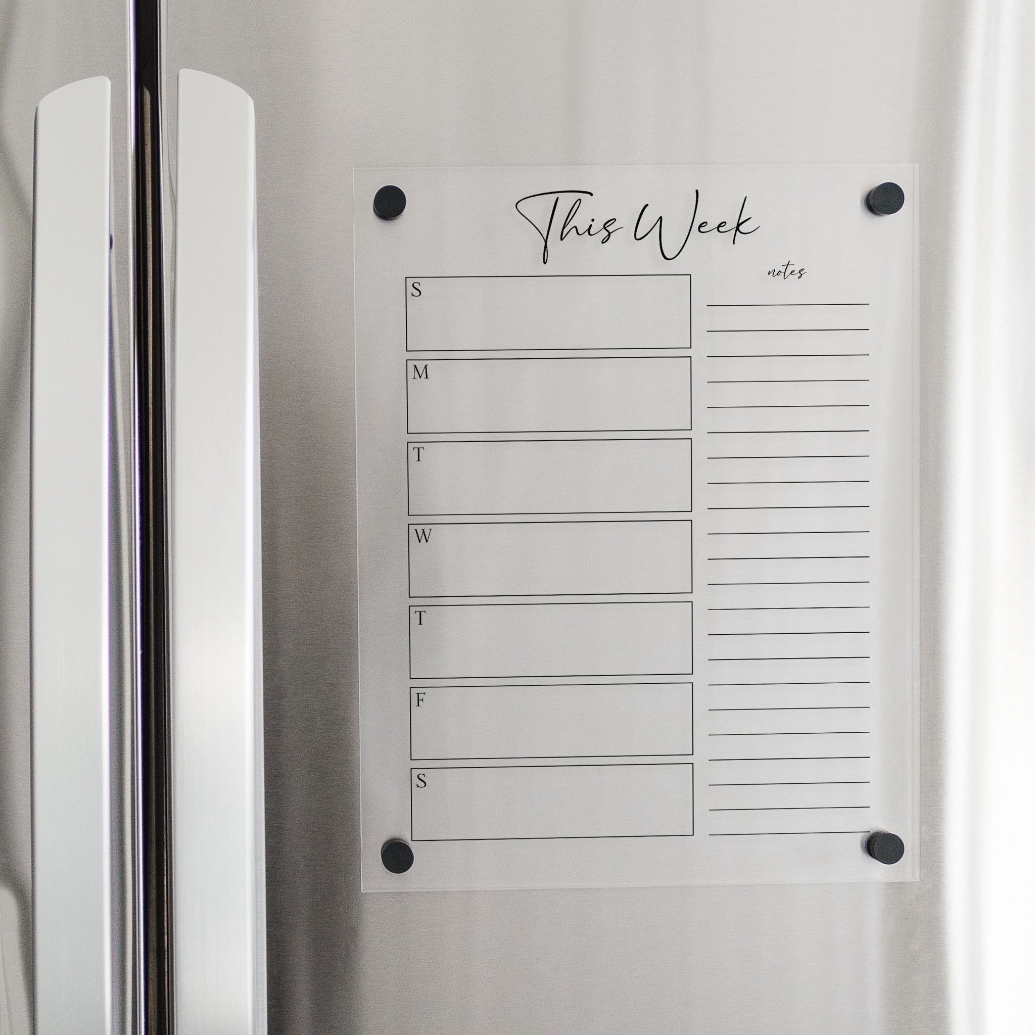 A Dry-erase weekly calender made of magnetic acrylic hanging on the fridge