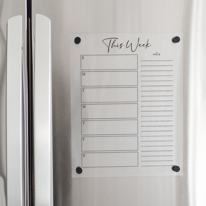 A Dry-erase weekly calender made of magnetic acrylic hanging on the fridge