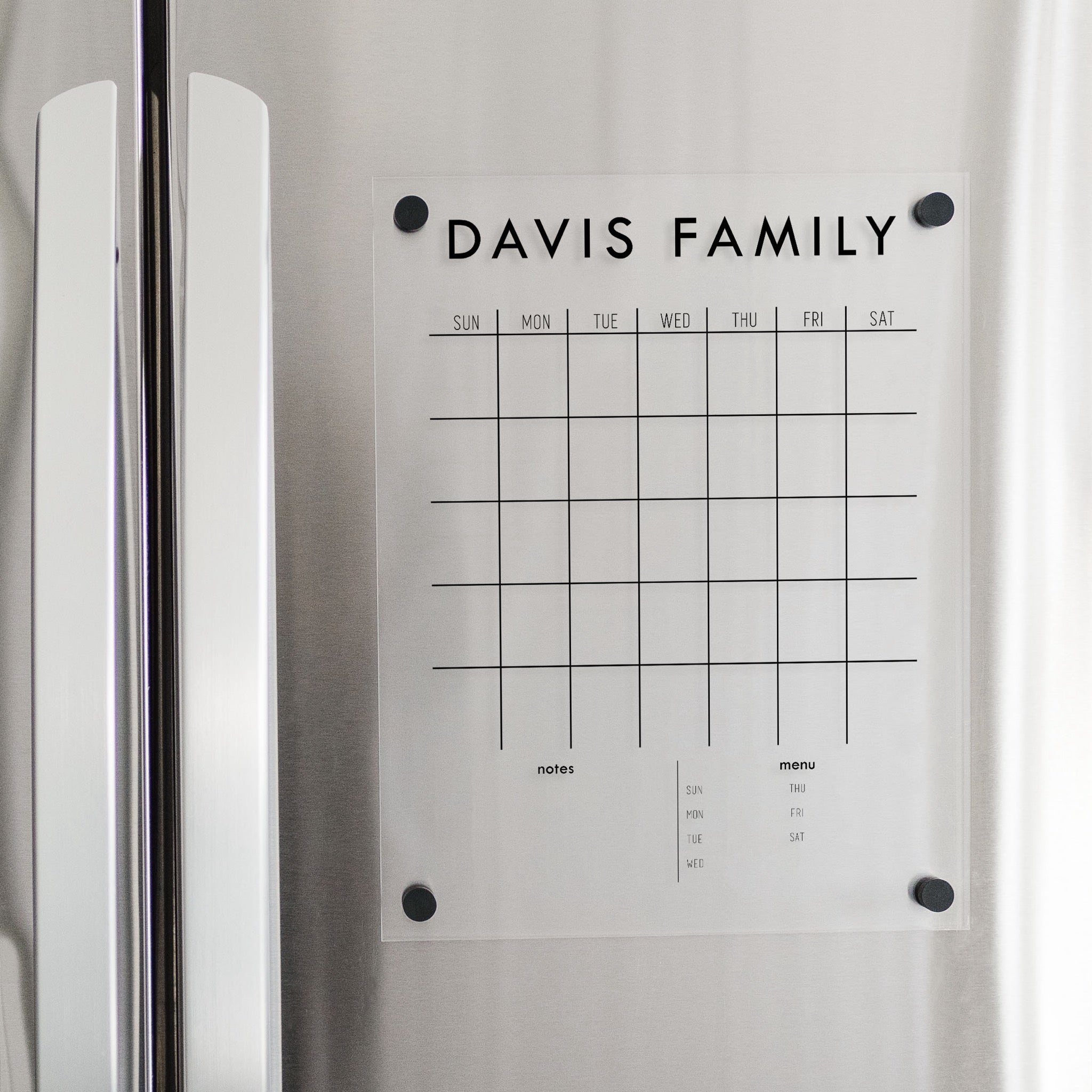 A Dry-erase monthly calender made of magnetic acrylic hanging on the fridge