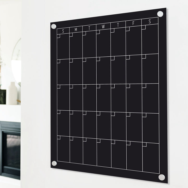 A Dry-erase monthly calender made of acrylic hanging on the wall