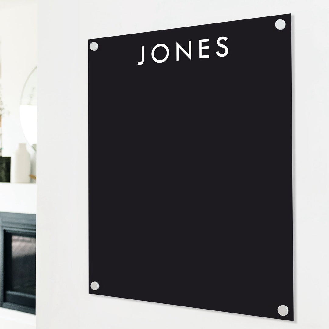 A dry-erase board made of clear acrylic with a custom title up top