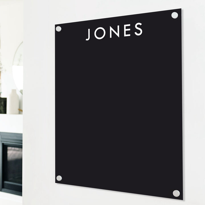 A dry-erase board made of clear acrylic with a custom title up top