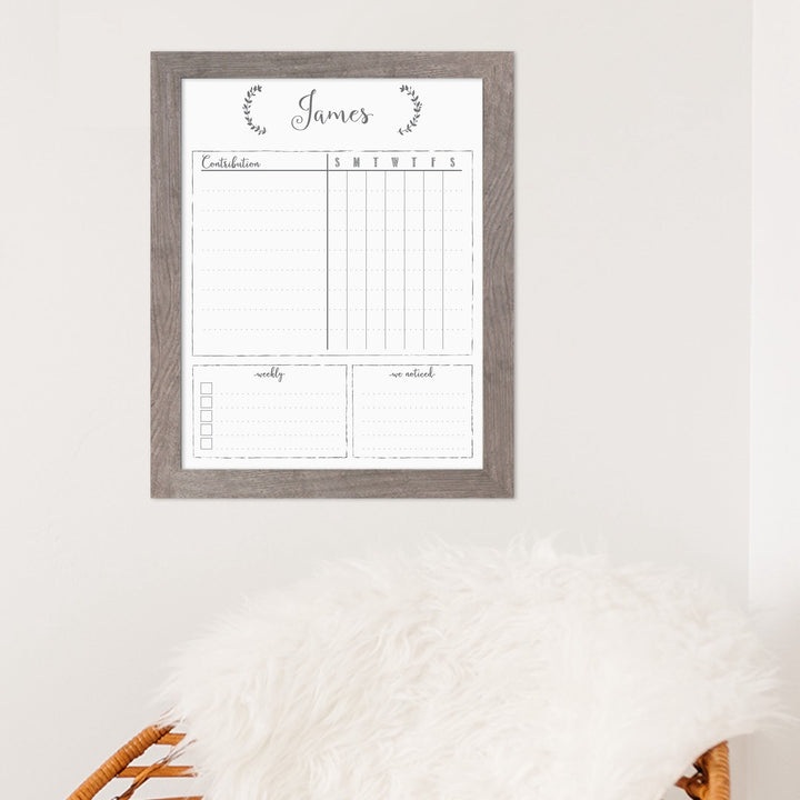 A framed whiteboard chore chart hanging on the wall